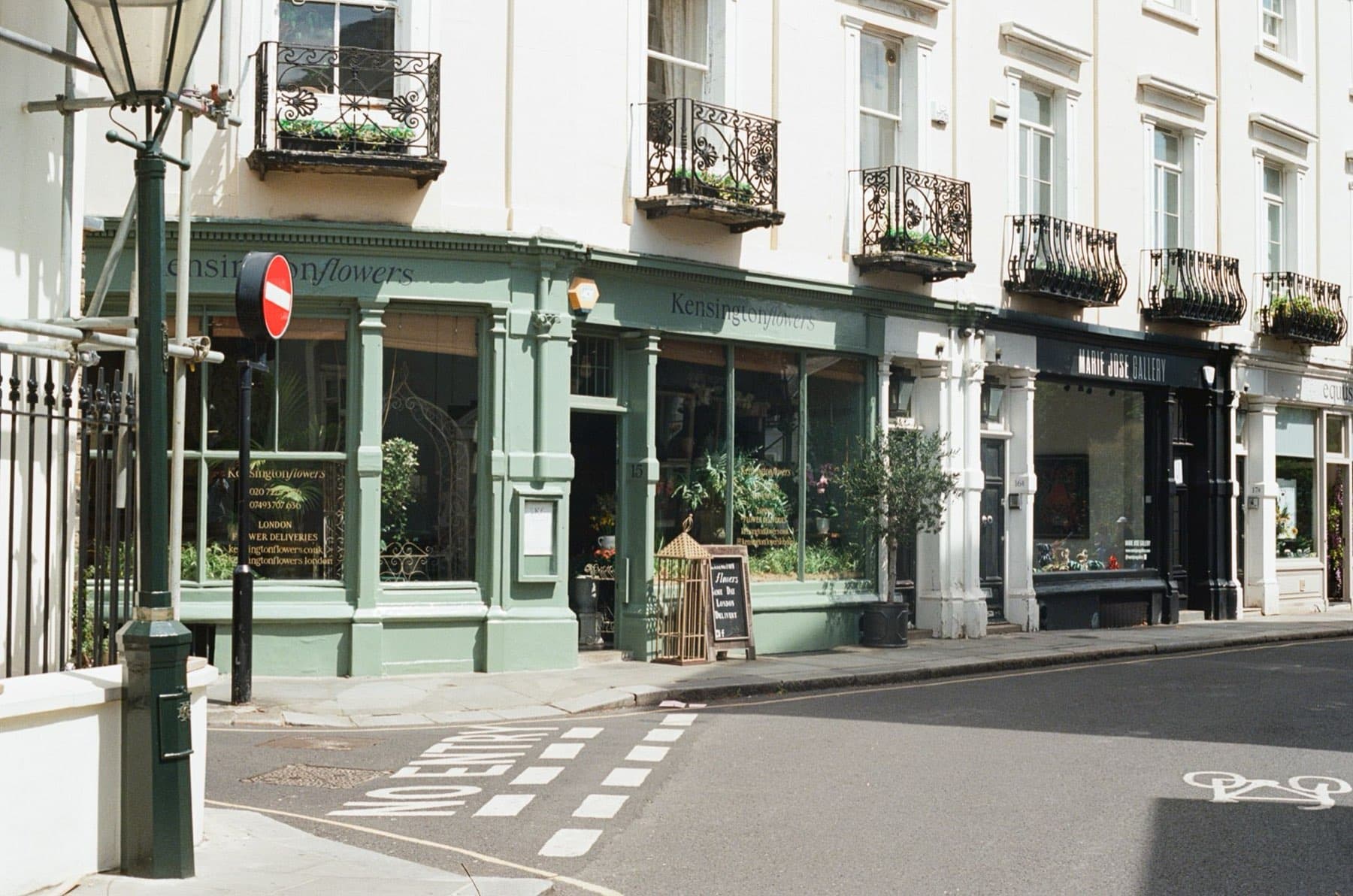 A green-painted florist shopfront and a small gallery in a white stucco Kensington terrace.